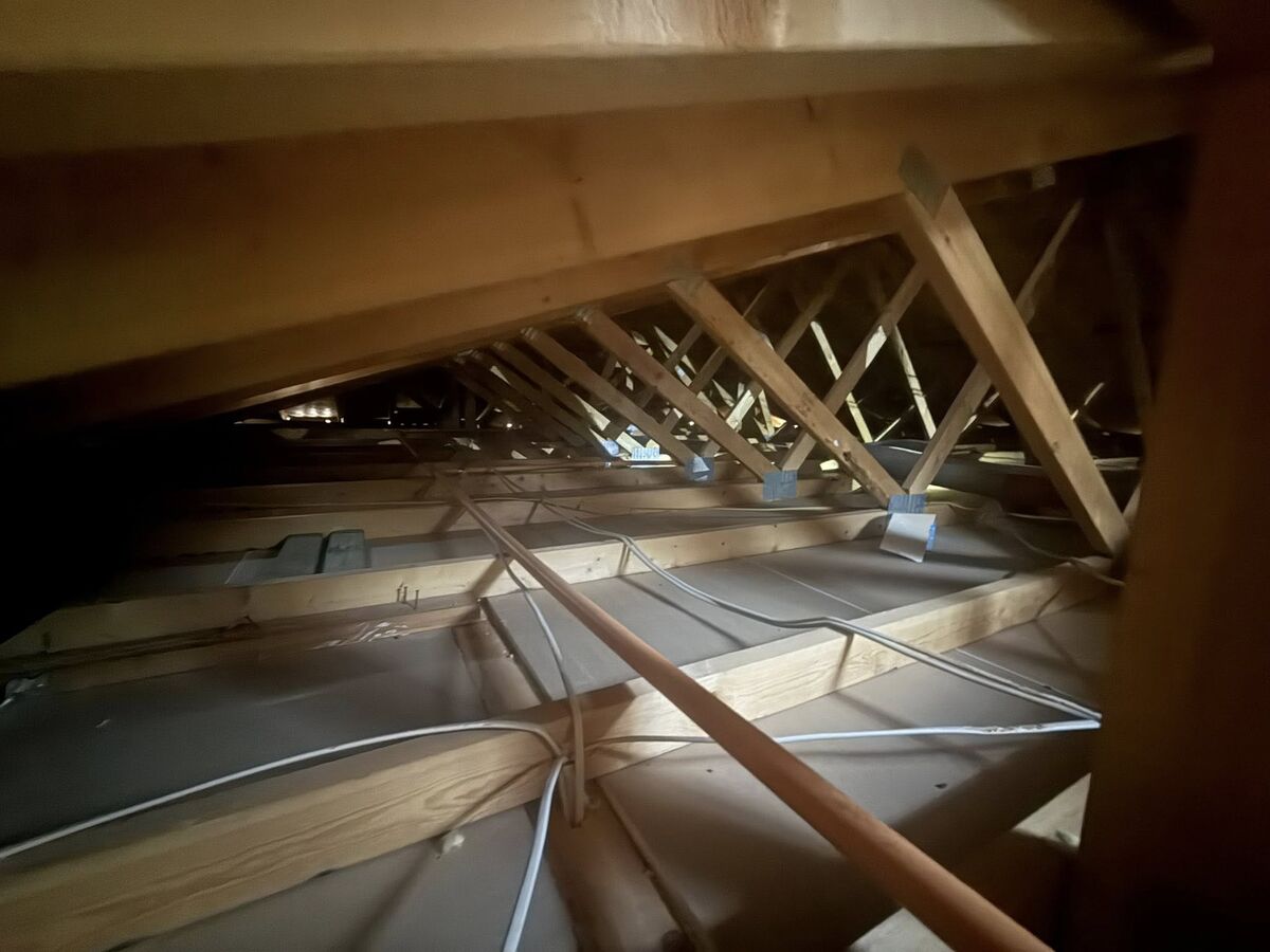Exposed attic rafters and roof decking in an Arizona home before insulation work