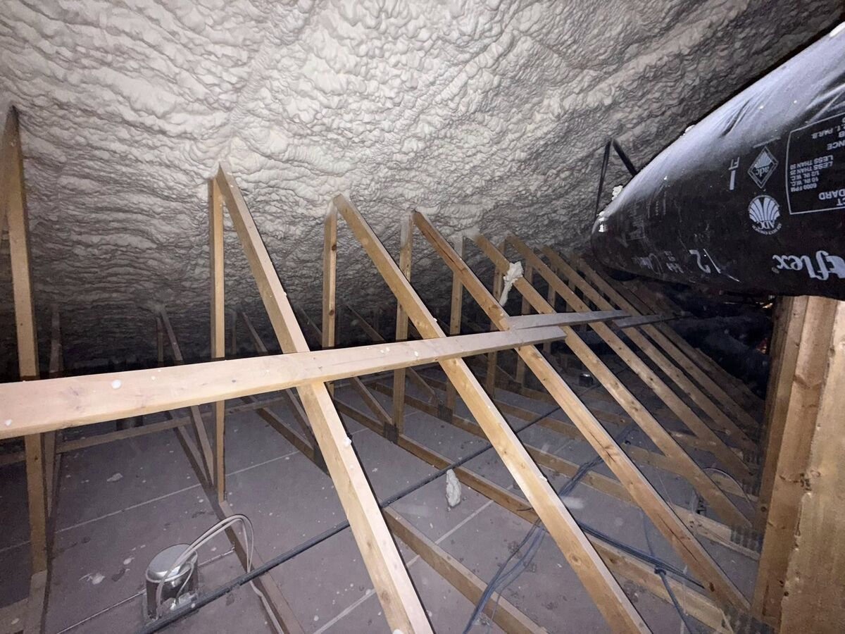 Spray foam insulation applied to the sloped roof rafters of an Arizona attic, the space that bakes second-floor rooms below